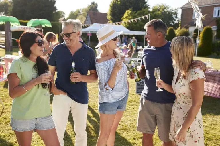 Mature Friends Enjoying Drinks At Summer Garden Fete