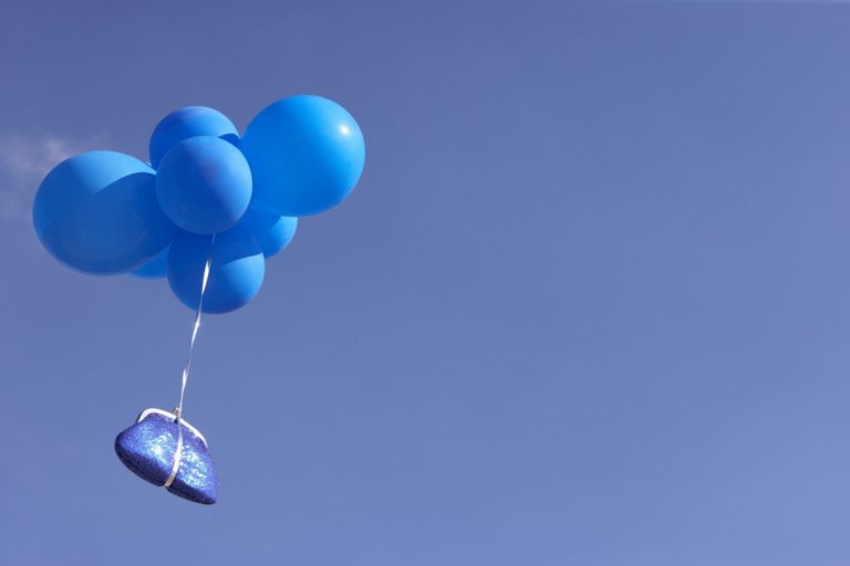 Blue purse flying with balloons