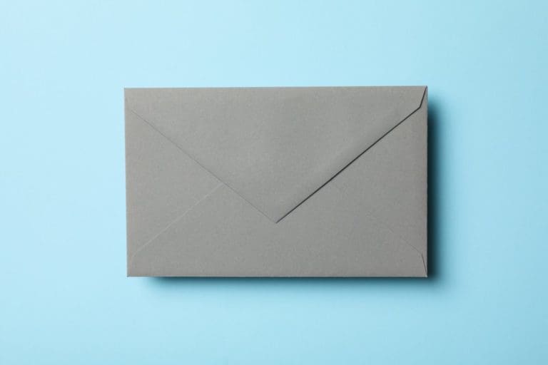Gray envelope on blue background, close up