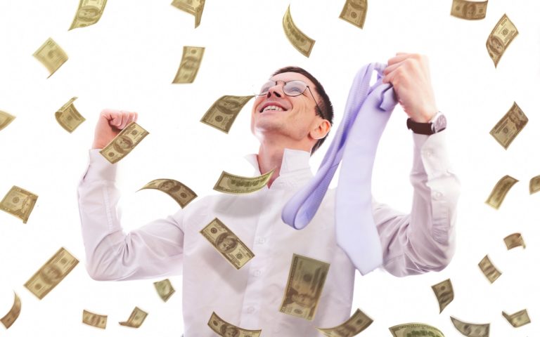 Happy businessman looking up for falling money