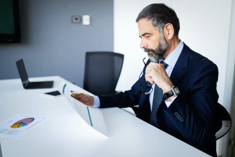 Shot of thinking financial advisor businessman working in office